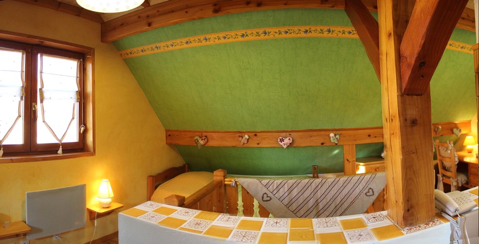 Cot lit d'une personne et bureau dans la chambre du Gite en Alsace